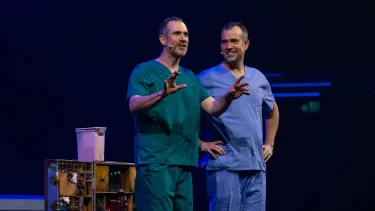Two men in the nurse uniform performing on the stage.